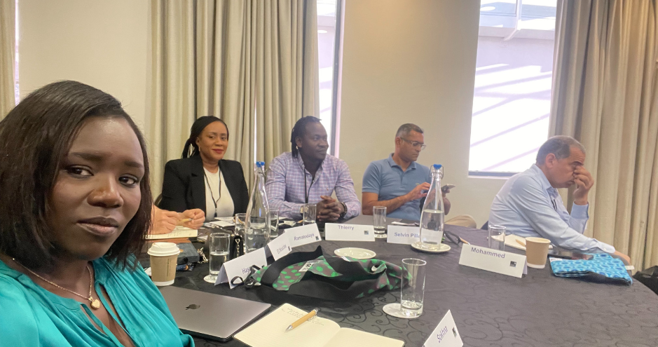 Sokhna Ndiaye assise en réunion autour d’une table, avec plusieurs participants.