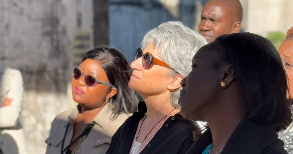 Groupe de participants attentifs lors d’une visite en extérieur, en pleine lumière