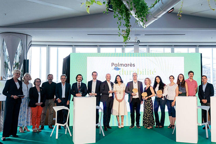 Un groupe de personnes sur scène, dont Victor Genin d'Accor, reçoit un prix. Derrière eux, un écran affiche «&nbsp;Palmarès de la durabilité&nbsp;» et le logo Deloitte.