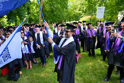 Bilal at graduation waving a flag