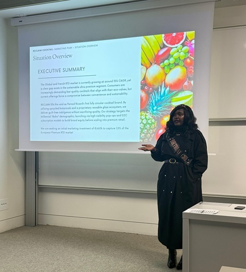 Aduh Kyalo wearing a crown and sash during a class presentation