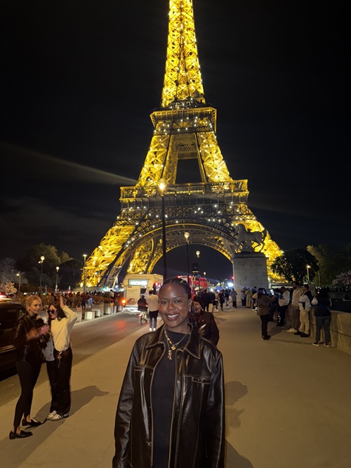 MBA student Kimberlee John standing in front of the Eiffel Tower at night