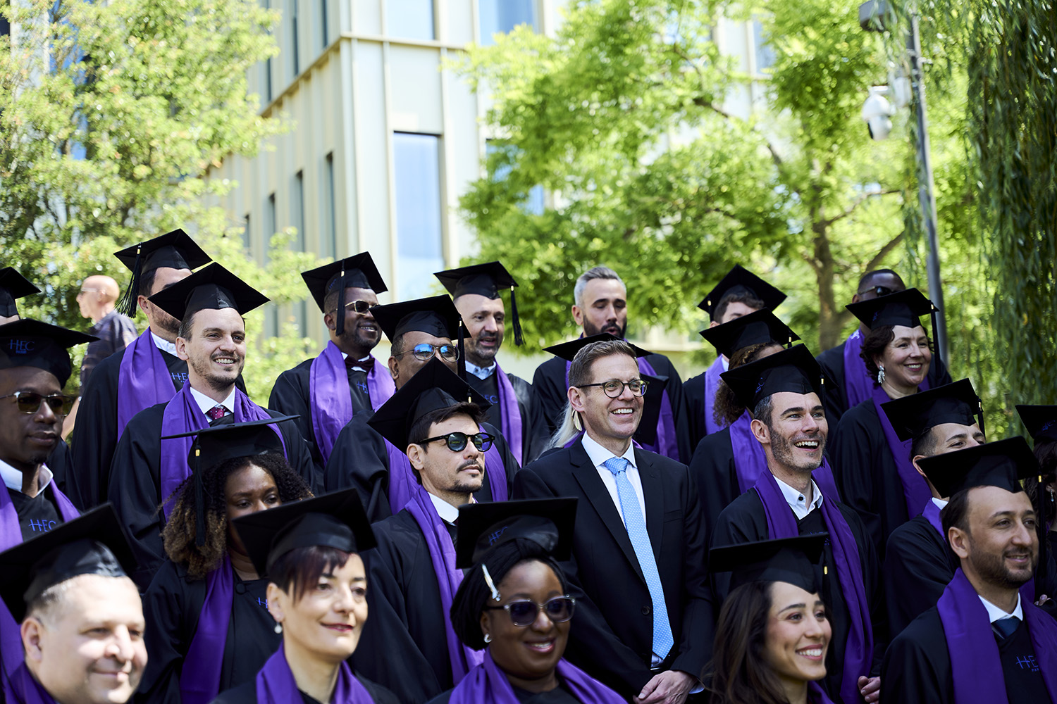 EMBA participants posing at graduation with Brad Harris