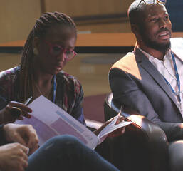 a colored man and a colored woman studying in business suits