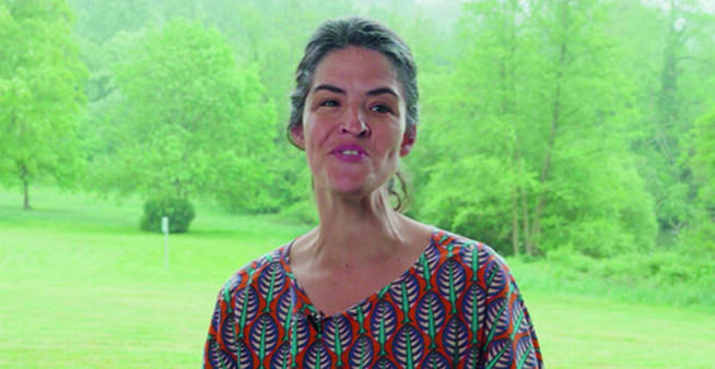 Chloé Renault, en extérieur devant un paysage verdoyant, s'adresse à la caméra