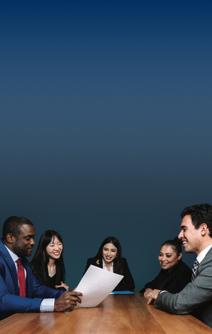 students sitting around a board room table dressed in business formal wear
