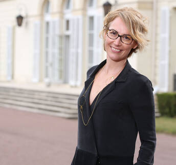 Femme devant un chateau qui sourit