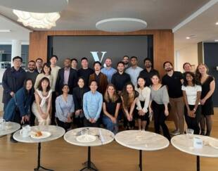 MBA students pose at a company visit during a club trek