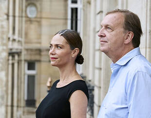 Deux experts de la gouvernance des entreprises familiales, debout sur un balcon, regardant l’horizon. 
