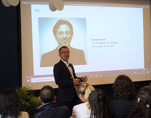 HEC Paris Professor presenting to an audience. A screen behind him displays a picture of Sergey Brin, co-founder of Google, in charge with Gemini
