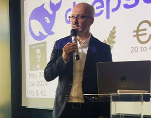 Vincent Fraitot, Associate Professor at HEC Paris, speaking during a masterclass on generative AI, standing at a podium with a microphone and presentation slides projected behind him.