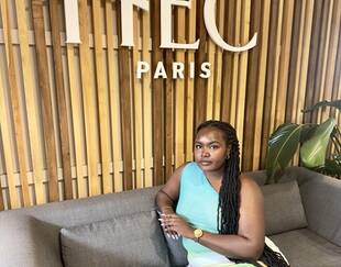 Aduh Kyalo sitting under the HEC Paris logo