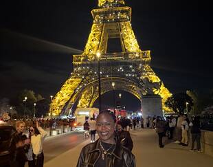 MBA student Kimberlee John standing in front of the Eiffel Tower at night