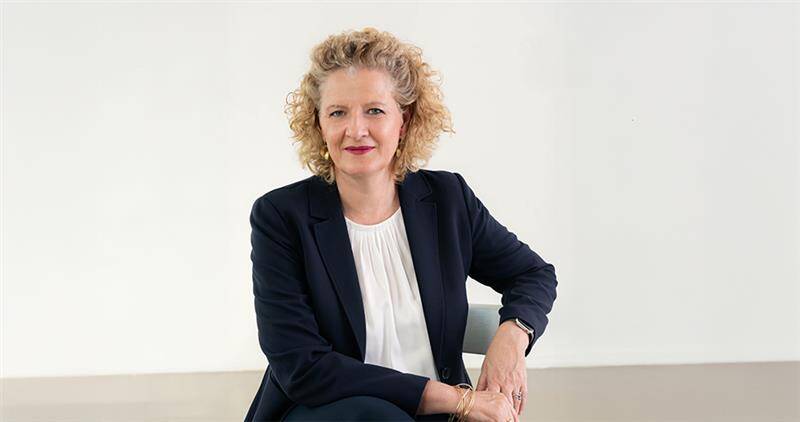 Portrait of the Dean of Executive Education at HEC Paris, seated and facing the camera, wearing a dark blazer and white blouse.