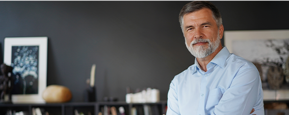 Portrait homme de cinquante ans qui sourit bras croisés